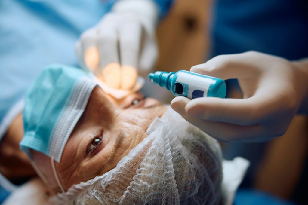 Close up of ophthalmologist giving her patient anesthetic drops before eye surgery.